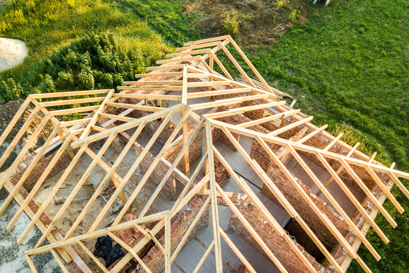 Aerial view of unfinished brick house with wooden roof structure